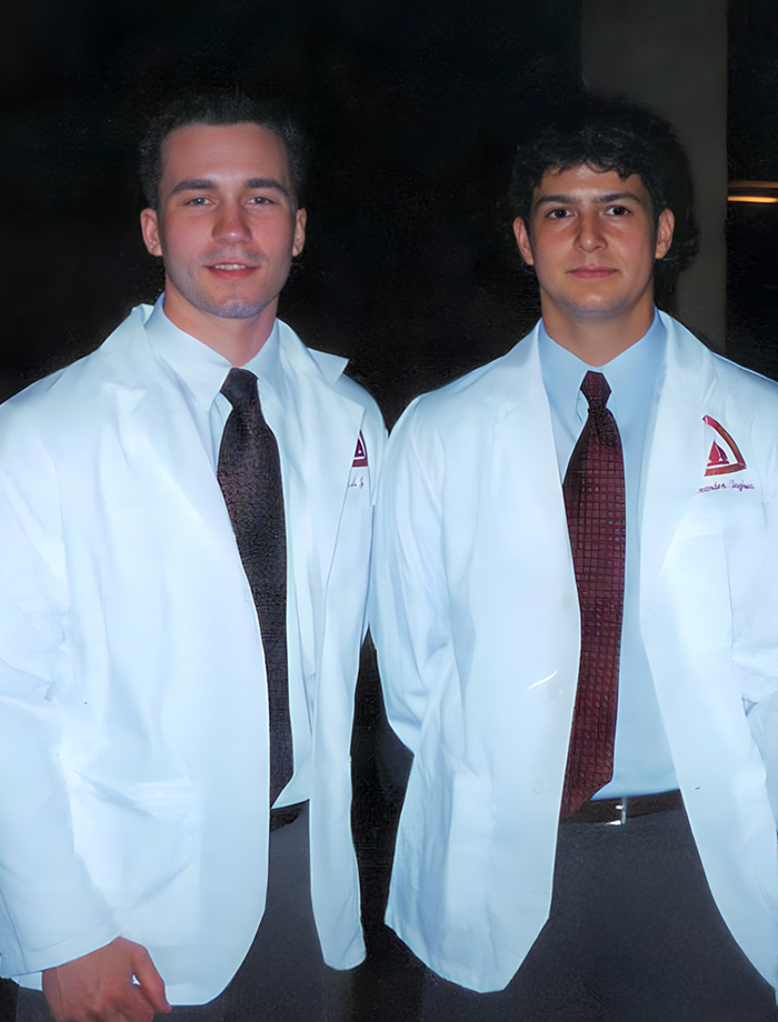 Two Johns Hopkins medical students in white coats supported by the Taghva Family Experiential Learning Fund for summer study