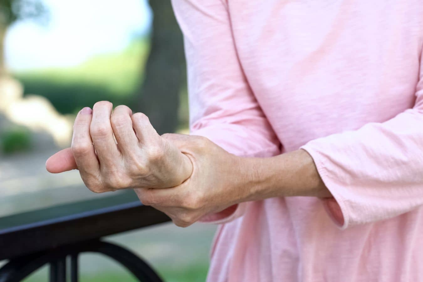 Person experiencing hand weakness and clumsiness, a symptom of cervical myelopathy that may require surgical treatment